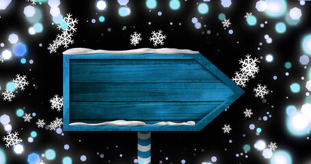 Image of christmas blue sign with copy space, snow falling and christmas fairy lights flickering