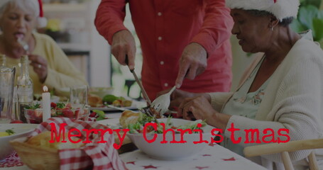 Image of christmas greetings text over diverse friends at christmas meal table © vectorfusionart