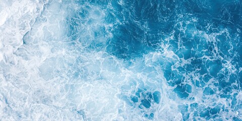 Fototapeta premium Aerial view of vibrant blue ocean waves crashing rhythmically, creating a stunning contrast of colors and textures.