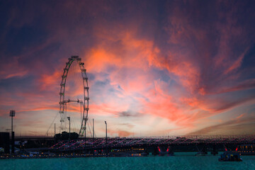 A vibrant sunset lights up the Ferris wheel landscape at dusk, creating an unforgettable view