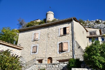 Fototapeta premium House in Provence village with chateau behind on hill