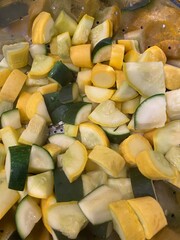sliced farm fresh organic yellow squash and zucchini (courgette) in stainless steel colander