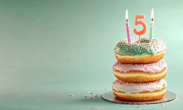 A colorful donut cake with a birthday candle and the number 5, celebrating a child's birthday.