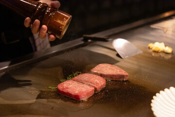 Grilled meat sizzling on a hot plate.
