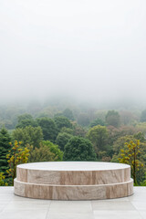 two-tiered round stone pedestal against a misty forest backdrop