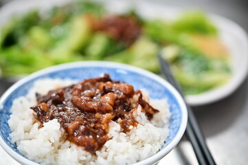 The savory braised pork rice combines tender pork with a flavorful soy-based sauce. This dish is complemented by the light, refreshing taste of blanched vegetables, balancing richness and freshness.