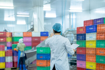 A factory worker wearing protective gear, organizing colorful storage crates in a clean and modern...