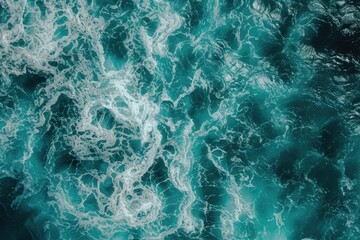 Fototapeta premium Aerial view of turquoise ocean water with splashes and foam.