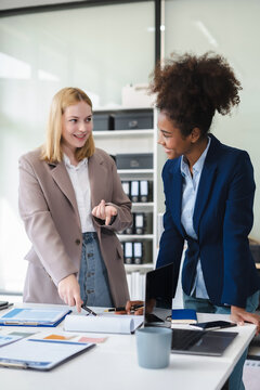 Diverse professionals collaborate on project analysis with financial graphs. Strategic teamwork and insights drive company growth and success.