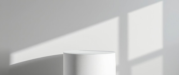 Fototapeta premium white cylindrical pedestal against a white wall illuminated by soft light