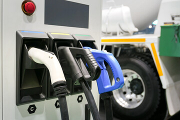 Electric car small home wall charger with cable. Plug for vehicle with electric engine. EV charger. Clean energy. Charging point at car parking lot. Future transport technology.