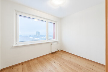Bright Empty Room With Wooden Flooring and Large Window Overlooking Urban Scenery. Home Interior