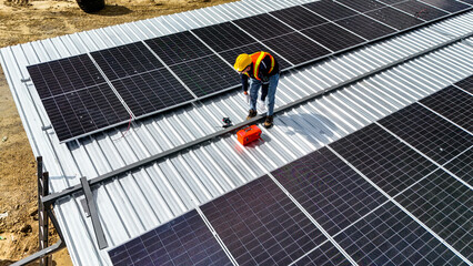 A worker wearing safety gear installing solar panels on a rooftop with nearby housing units in the background, emphasizing renewable energy, sustainability, and efficient solar power implementation