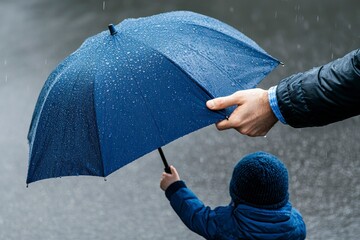 A caring adult holds a blue umbrella over a young child in the rain, showcasing the bond of protection and warmth during a rainy day in a city setting.
