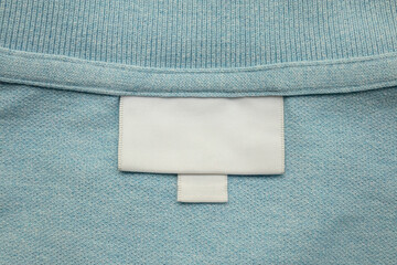 White blank laundry care clothes label on shirt fabric background