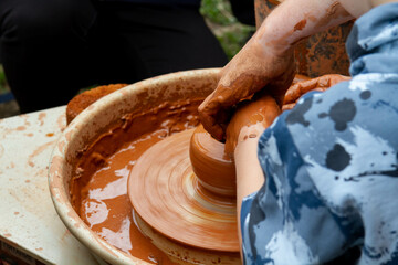 Pottery training. Rotating a clay pot on a machine. Hands knead clay. Making a clay pot..