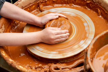Pottery training. Rotating a clay pot on a machine. Hands knead clay. Making a clay pot..