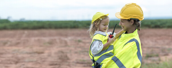 Female engineer holds and hugs daughter. Caucasian Family in the community with wind generators...