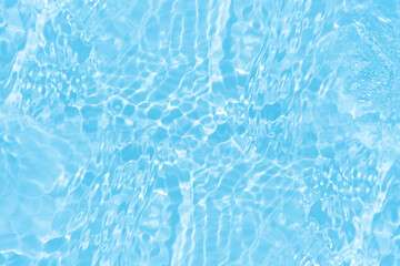 Blue water with ripples on the surface. Defocus blurred transparent blue colored clear calm water surface texture with splashes and bubbles. Water waves with shining pattern texture background.