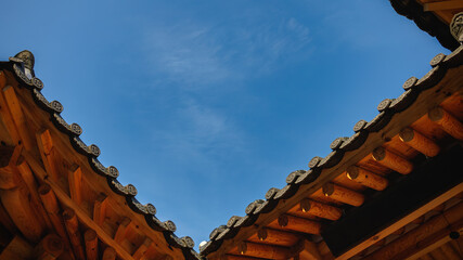 Obraz premium The angular blue sky seen from under the eaves of a Korean traditional house (Hanok)