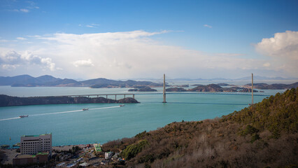 Naklejka premium It is a beautiful landscape with an emerald sea, a suspension (or cable stayed) bridge, and many islands.