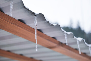 Icicles hanging from a roof during wintertime