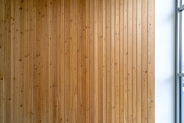 Wooden wall with vertical panels, showcasing natural texture and warmth. light enhances grain, creating cozy atmosphere in space