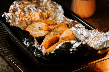 Baked trout steak with lemon prepared in foil for a delicious outdoor fire-cooked meal
