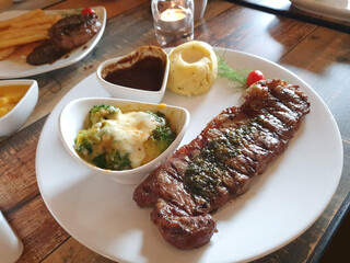 Oily steak paired with creamy mashed potatoes and rich barbecue sauce. The glistening textures and vibrant colors make it ideal for menus, food blogs, restaurant promotions, or culinary advertising