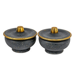 Two decorative bowls with lids, featuring a dark texture and golden accents, showcasing elegant craftsmanship.