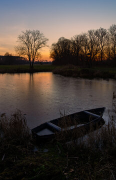 The setting sun, an old boat on a frozen pond, Masovia, central Poland