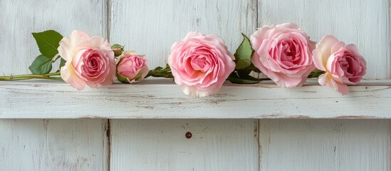 Elegant arrangement of delicate pink roses on a rustic white wooden shelf ideal for vintage decor and floral styling inspiration