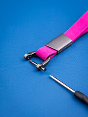 Close up of metal mount of minimalist keychain with screwdriver on blue background