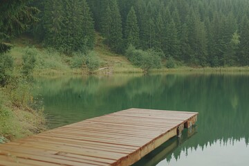 Obraz premium Tranquil Wooden Dock on Serene Lake Surrounded by Lush Green Forest Landscape
