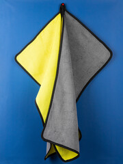 Close-up yellow and gray fleece cloth from dirt and dust for cleaning house and car on blue background