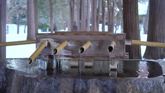 Sapporo, Hokkaido,Japan-Dec 16,2024: Water pond at Hokkaido shrine temple for cleaning or drinking prayer Wishing Pray for happiness, healthy, lucky on stand Hokkaido shrine