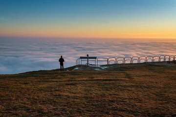 Man and the beauty of nature. Silhouette of a hiker on a hill with an inversion at sunset. Nature...