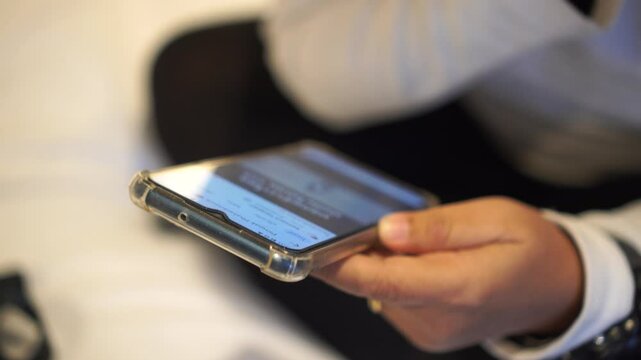 Hands holding smartphone pressing fingerers, reading social media internet, typing shopping online at home or work