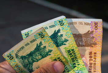 Moldovan money hand. Moldavian banknotes of 20 and 100 lei in hand. Moldovan LEI currency, close up. Making payments, inflation and economic situation concept
