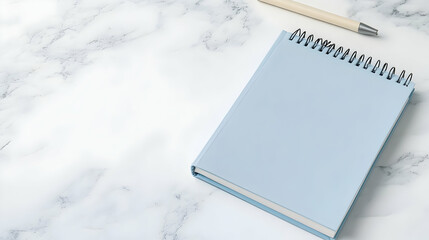 Pastel blue notebook and pen on marble desk;  workspace mockup; planning, note-taking.