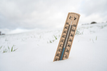 Thermometer in snow covered landscape, cold frosty weather forecast in winter, measure the...