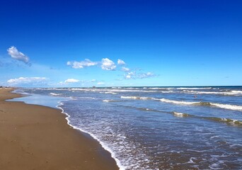 beautiful sandy beach and the sea under a blue sky with clouds