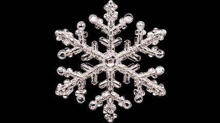 Silver beaded snowflake ornament isolated on black background.