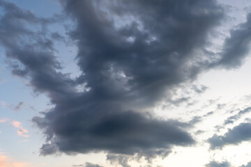 Obraz premium Low angle view of dark sky with strange shape of fluffy black clouds in the morning or evening while sunset or sunrise used as natural background texture in decorative art work