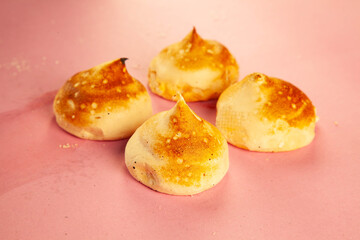 Scone donuts with strawberry jelly and meringue and vanilla custard on a pink background.