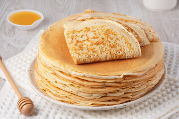 Stack of traditional russian pancakes blini on a white table. Homemade russian thin pancakes blini....