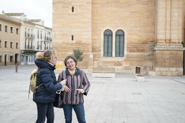 Two senior tourists enjoying a cultural tour in a historic city plaza © C&A