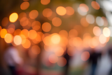 Fototapeta premium A blurred image featuring a series of warm orange bokeh lights, creating a dreamy and festive atmosphere. The lights are scattered and form abstract patterns against a soft background.