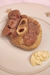 Close-up of cooked pork shank on a plate on the table