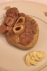 Close-up of cooked pork shank on a plate on the table
